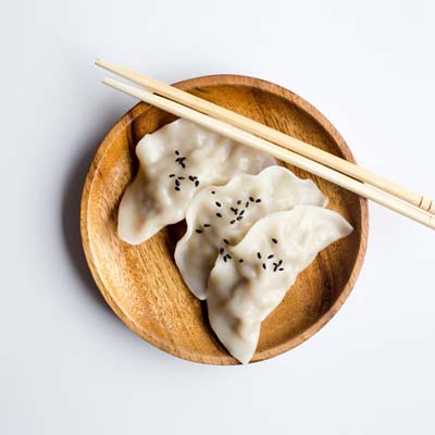 potstickers on a plate with chop sticks