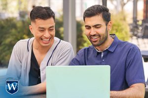 Westcliff University students studying together on laptop outside