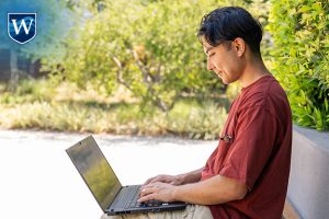 Westcliff University student studying on laptop outside