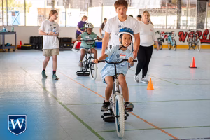 Children learning to ride bikes with their teachers